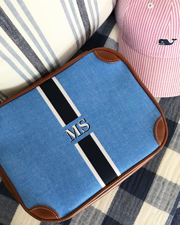 Blue Striped Monogrammed Cosmetic Bag with Leather Patch on Fabric Background
